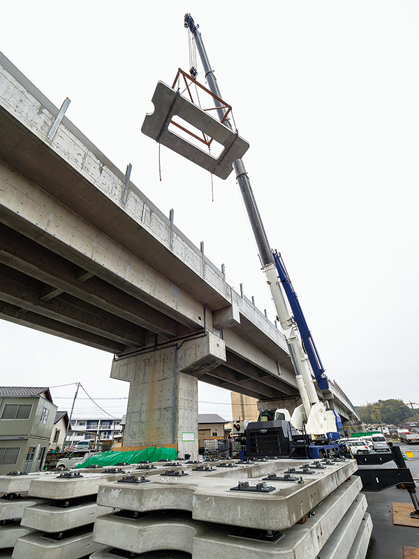今寺軌道基地で、工場から運搬されてきた軌道スラブをクレーンで高架線上に搬入する